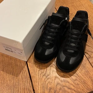 Maison Margiela ”gats” svarta - Riktigt fina Maison Margiela gats sneakers i helsvart med ovandel i lammnappa och calvskinn i storlek 44 1/2 passar även 44. Skorna är i toppskick och box, dustbag o skorna ingår🤝 Kan gå ner i pris vid snabb affär!🏌️🏌️ fraktas inom 24h✅