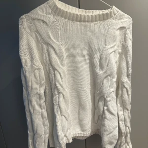 Vit stickad tröja XS - Säljer en vit stickad tröja från 157 i storlek XS. Tröjan har grova flätstickade detaljer längs ärmar och sidor, samt en bred ribbad rund halsringning. Perfekt för dig som gillar chunky knit och vill ha en mysig look.