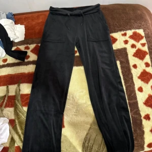 Svarta mjukisbyxor från 157, storlek S - Svarta mjukisbyxor från 157 i storlek S. Byxorna har dragsko i midjan, två stora fickor fram och är tillverkade i ett mjukt, fleeceliknande material. Perfekta för chill eller träning, med en loose och bekväm passform.