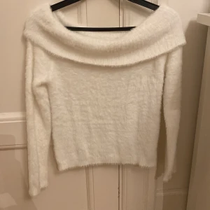Vit fluffig offshoulder tröja Kappahl - Supermjuk och fluffig vit tröja från Kappahl med bred offshoulder-ringning. Långärmad och i ett mysigt material som känns lyxigt och varmt. Perfekt för dig som gillar stilren och cozy vibe. Snygg att matcha med jeans eller kjol. Perfekt nu till höst och vintermånaderna. Aldrig använd men har tagit bort lapp.