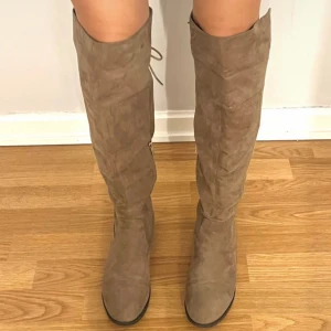 Beiga stövlar  - Snygga stövlar i beige med låg klack och rund tå. Stövlarna har dragkedja på insidan och knytning upptill för extra passform. Perfekta för att lyfta din outfit under höst och vinter💕