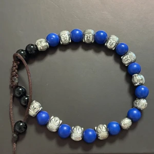 Blått armband med buddha-pärlor - Unikt armband med blåa runda pärlor och silverfärgade buddha-huvuden. 
