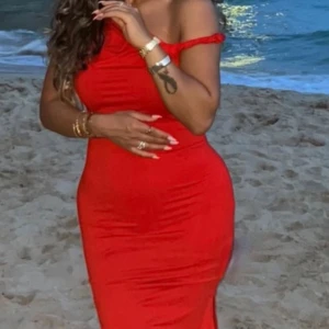 Röd offshoulder långklänning - Snygg röd långklänning med offshoulder-design och figurnära passform. Perfekt för dig som vill sticka ut med en klassisk och trendig look. Klänningen har inga synliga mönster och är enkel men elegant.