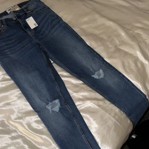 snygga skinny jeans med hål i knäna  - skinny jeans med hål på vardera knä, nya. Inte använda ! 