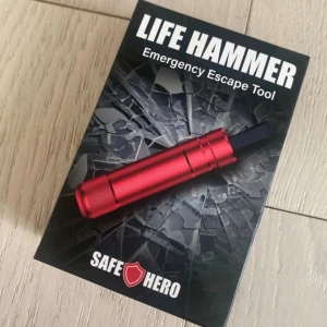 Life Hammer Emergency Escape Tool - Praktiskt nödverktyg för bilen, designat för att krossa rutor och skära säkerhetsbälten vid nödsituationer. Kompakt och robust i röd metall. Produkten är ny i förpackning och perfekt för ökad säkerhet i fordonet.