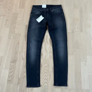 Helt nya jeans från Tiger of Sweden W29 L30 - Sprillans nya gråsvarta jeans från Tiger of Sweden med modellen slim. Jeansen har lätta slitningar och är tillverkade med italienskt premium denim vilket ger dom superbra kvalite. Materialet är stretchigt och därför passar jeansen inte bara till 29 midja utan också till 30 utan problem. 