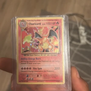 Charizard - Sällsynt och glittrande Charizard Pokémon-kort! Perfekt för samlare och fans som vill ha en ikonisk och kraftfull karaktär i sin samling. Kortet är skyddat i plastfodral och har coola effekter och starka attacker. Ett måste för alla Pokémon-entusiaster!