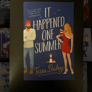 It Happened One Summer - En charmig och modern feelgood-roman med somrig stämning. Perfekt för dig som gillar romantik, humor och oväntade möten. Omslaget utstrålar flirtig energi och lockar till en lättsam läsupplevelse.