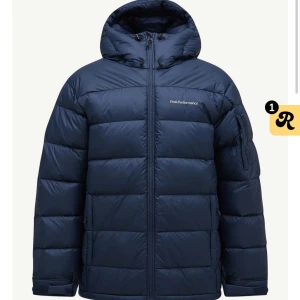 Mörkblå dunjacka Peak Performance - Säljer en mörkblå dunjacka från Peak Performance med huva och dragkedja framtill. Jackan har en quiltad design och logotyp på bröstet. Perfekt för kalla dagar och har en klassisk, sportig look. Storlek M men passar S, perfekt jacka om man vill ha hoodie under. Nypris 4200kr
