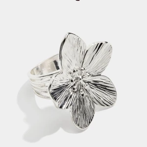 Silvrig ring med stor blomma - Superfin ring i silver med ett vackert blommotiv! Strilren men ändå detaljrik - perfekt både till vardags och fest. Ringen sitter bekvämt på fingret och ger en feminin, elegant touch till villkor outfit som helst. Har typ inte använt den någon gång💕