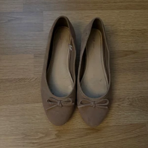  ballerinaskor med rosett  - Snygga beiga ballerinaskor i mocka som inte används längre