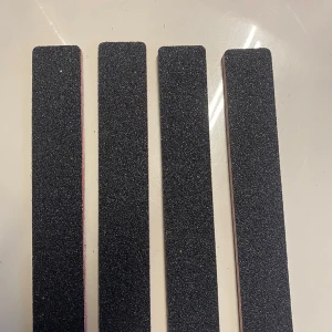 Svarta nagelfilar i fyrpack - Fyra svarta nagelfilar med rektangulär form och grov yta, perfekta för att fila och forma naglarna. Filarnas material är sandpapper på en stabil kärna, vilket gör dem enkla att använda för både naturliga och konstgjorda naglar.