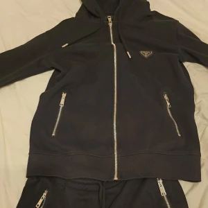 Prada tracksuit - Säljer nu en svart tracksuit från Prada. Mjukt bomull för en stilren look. Först till kvarn, passa på och fynda🚀 Vid frågor & funderingar hör gärna av dig!