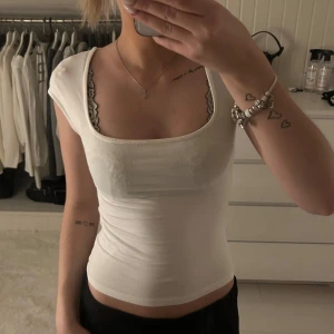 Vit croppad topp från Gina Tricot - Säljer en vit croppad topp från Gina Tricot med fyrkantig ringning och korta ärmar. Toppen är figurnära och tillverkad i mjuk bomullsmix, perfekt att styla med. Super fin och söt topp. Använda fåtal gånger. Storlek xs och pris:150kr 