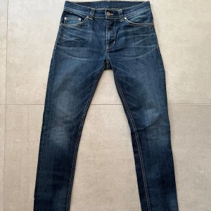 Blå DonDup jeans, storlek 33 - Snygga mörkblå Replay Anbass jeans i klassisk femficksmodell med kontrastsömmar och coola detaljer på bakfickorna. Slim passform och raka ben, tillverkade i slitstarkt jeanstyg. Perfekt för dig som gillar stilrena och moderna jeans.