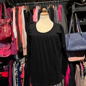 Svart långärmad blus med rund hals - Säljer en svart blus med lång ärm och rundad halsringning. Modellen har en lös passform med lätt rynkade detaljer upptill. Perfekt för dig som gillar enkel och stilren design. Storleken är en M/L