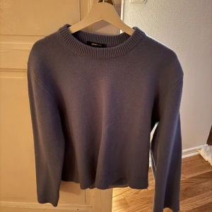 Blå stickad tröja från Gina Tricot - Mysig blå stickad tröja från Gina Tricot med rund halsringning och ribbade muddar. Perfekt för lager-på-lager och enkel att styla med jeans eller kjol. Klassisk modell med lång ärm och mjuk känsla.
