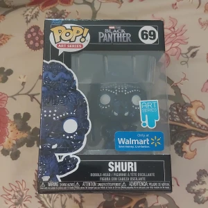 Funko Pop! Art Series Shuri #69 Black Panther - Funko Pop! Art Series Shuri #69 från Black Panther, exklusiv Walmart-utgåva. Figuren är i originalförpackning och oskadd, perfekt för samlare. Snyggt konstnärligt mönster designat av Damion Scott. Lådan ser ut att vara i mycket gott skick.