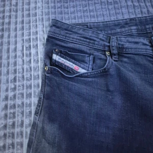Svart jeans från Diesel - Vintage svarta jeans från Diesel med en klassisk femficksdesign. De har en rak passform och är tillverkade i stretchigt material för extra komfort. Perfekta för en avslappnad stil. 