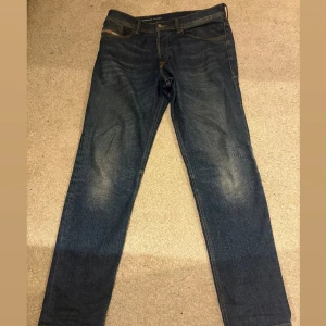 Diesel jeans blå 32/32 - Snygga blå jeans från Diesel. Jeansen har klassisk rak passform. Materialet är slitstarkt denim i bomull. Storlek 32/32.