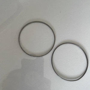 Två tunna silverfärgade armband - Säljer två stilrena, tunna armband i silverfärg. De är runda och minimalistiska, perfekta för dig som gillar enkel och clean stil. Passar snyggt att bära tillsammans eller var för sig för en diskret look.