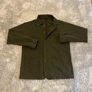 Olivgrön overshirt med fickor - Skön olivgrön overshirt från uniqlo. Storleken är s men den är stor i storleken, är mer som M/L. Riktigt bra skick! Hör gärna av er vid frågor.