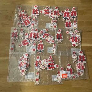 9 paket Röda tomtefigurer att hänga i granen  - Säljer ett gäng pappersfigurer med klassiska röda tomteluvor, perfekta för julpynt eller DIY-projekt. Figurerna har olika motiv med tomtar och nissar, alla med röd luva och detaljer i vitt och grått. Passar dig som vill ha en mysig julkänsla hemma. 20kr styck