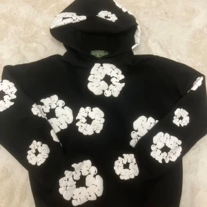 Denim Tears Hoodie - Svart Denim Tears hoodie med tryck fram och bak. Trendig, Skön och oversized passform. Lätt använd och välskött. Den är i topp skick och värt för priset.