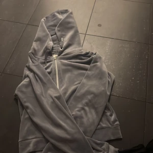 Grå velourhoodie från Gina Tricot - Mjuk och skön grå hoodie i velour från Gina Tricot. Tröjan har dragkedja framtill, huva och långa ärmar. Perfekt för dig som gillar en chill och avslappnad stil.