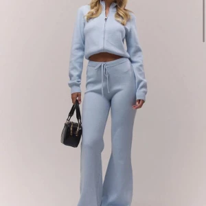 Blå stickade mjukisbyxor med utsvängda ben - Snygga ljusblå stickade mjukisbyxor från MUSERA med dragsko i midjan och utsvängda ben. Byxorna har en avslappnad passform och är perfekta för chill dagar. Materialet är mjukt och stretchigt, vilket gör dem riktigt sköna att bära.