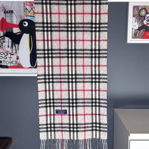 Burberry halsduk - Vi säljer nu denna extremt schyssta halsduk från bland ett av de mest kända halsduks-tillverkarna genom tiderna. Detta stilrena mönster kombinerat med 100% Kashmir erbjuder dig en varm och skön vinter.  Cond 8.5/10 (lappen har lossnat på ena sidan och det finns en fläck)  Nypris: 5400 kr - Vårt pris: 1399 kr . Endast halsduken som medföljer vid köp. 