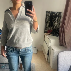 Stickad tröja med krage - Stickad tröja med v-ring och krage i färgen grå, köpt på Hm men kommer inte till användning längre. Tröjan är i fint skick utan några defekter. Kontakta mig gärna vid frågor💕☺️