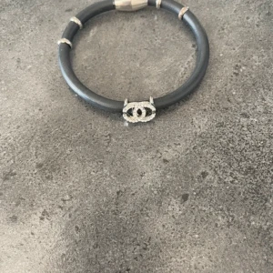 Svart armband - Snyggt svart armband i silver och glittriga pärlor. Armbandet har en rund form och detaljer i silverfärg som ger en lyxig känsla. Perfekt för dig som gillar exklusiva accessoarer med ikonisk design.