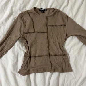 Ljusbrun topp med mönster - En ljusbrun (lite åt de beiga håller) topp med mönster som aldrig kommit till användning.🫶🏼 Är köpt från missguided och är i storlek 36 (s)❤️