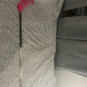 Salming Carbon Pro innebandyklubba - Salming Carbon Pro innebandyklubba med svart skaft och rosa blad. Klubbans grepp är vitt och ser ut att vara i gott skick, med minimalt slitage. Perfekt för både träning och match. Lätt och hållbar konstruktion för optimal spelupplevelse. Pris kan diskuteras 