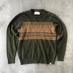 Mörkgrön stickad tröja från Revolution - Jävligt nice mörkgrön stickad tröja från Revolution i storlek M. Jävligt fett orange mönster över bröstet och ryggen. 