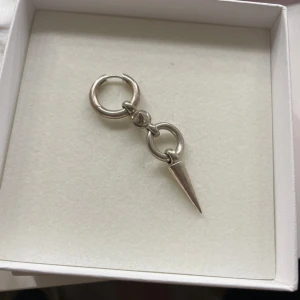 Silverörhänge med spike från Syster P - Coolt örhänge i silver från Syster P med två ringar och en spetsig spike-detalj. Minimalistisk men edgy design som ger en unik touch till din stil. Perfekt för dig som gillar smycken med attityd. Hör gärna av dig vid funderingar!❤️❤️❤️