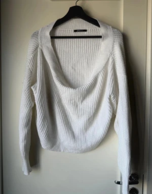 Vit stickad tröja off shoulder  - Säljer en vit stickad tröja från Gina Tricot med off shoulder. Tröjan har ribbad struktur och långa ärmar, perfekt för att skapa en chill och snygg look. Passar dig som gillar mjuka material och vill ha en tröja med lite extra attityd.