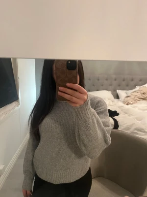 Grå stickad tröja  - Säljer en enkel och snygg grå stickad tröja från bikbok med rund hals och ribbade muddar vid ärmslut och nederkant, inga synliga defekter!