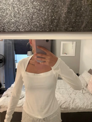 Tröja  - Säljer en stilren vit långärmad tröja med snygg fyrkantig halsringning. 