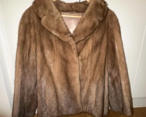 Otroligt vacker äkta minkpälsjacka - ljusbrun - 100 % äkta  minkpäls. Oanvänt skick : Elegant brun pälsjacka med krage. Jackan har ett vackert foder med diskreta broderier. Passar S/M , perfekt för dig som vill sticka ut och hålla värmen under kyliga dagar.