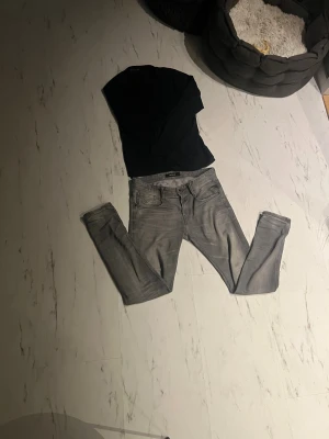 Replay jeans - Säljer ett par snygga Replay jeans i grå tvätt med skinny passform. Jeansen har klassisk femficksdesign, svarta sömmar på bakfickorna och detaljer med Replay-logga. Materialet är stretchigt jeans och midjan är normal. Perfekt för dig som gillar stilrena och moderna jeans.