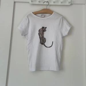 Vit t-shirt med leopardtryck från subdued - Vit t-shirt från subdued med ett snyggt leopardtryck på bröstet. Klassisk rund halsringning och korta ärmar. Skön och mjuk bomull som passar perfekt till jeans eller shorts.