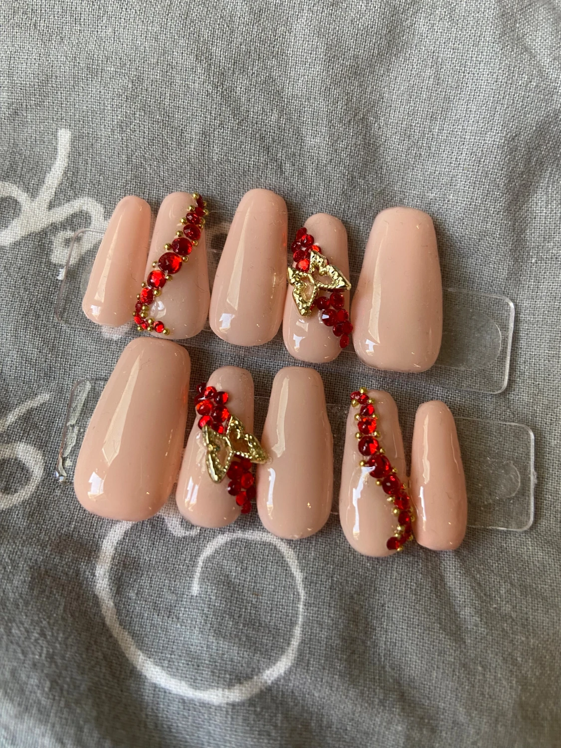 Nude lösnaglar med röda stenar