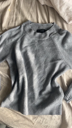 Grå stickad tröja från Vero Moda - Mysig grå stickad tröja från Vero Moda i storlek S. Tröjan har rund hals, ribbade muddar vid ärmslut och nederkant samt långärmad passform. Perfekt för vintern nu!💕