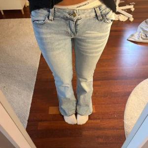 Lowewaist Bootcut jeans från Cheap Monday ljusblå - säljer mina jättesnygga jeans för att de är lite stora för mig❤️säljer så jag kan köpa i storlek 27/32 eller så gör jag gärna byte för att få den storleken❤️byxorna är ljusblåa med vita ”sträck” högst upp på benet❤️Inga defekter❤️sätter på köp nu när du ska köpa❤️
