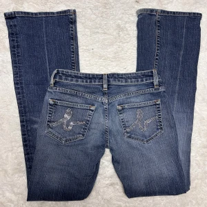 Bebe jeans Lågmidjade bootcut jeans 2000s y2k Bebe lowrise lowwaist  - Äkta vintage Bebe jeans. Står storlek 27 men de är  små i storleken och passar därför en 26 bättre. (Se mått) Innerbenslängd:80 midjemått: 36. Har inga bilder på då de är försmå. Köp sker via köp nu, jag postar inom 24h. Kvar tills markerad såld.