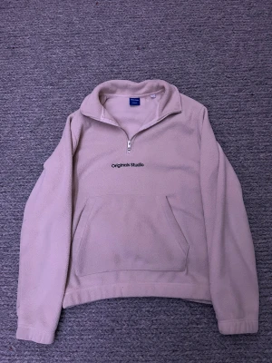  Jack & Jones hoodie - Mjuk och skön tröja från Jack & Jones Originals Studio. Tröjan har en half zip-dragkedja, lång ärm och en stor magficka framtill. Perfekt för kyliga dagar och enkel att matcha med. 