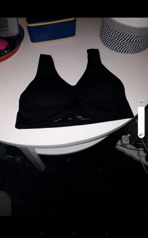 Svart ärmlös linnetopp - Säljer en svart, ärmlös linnetopp med breda axelband och v-ringning. Toppen är i mjukt material och har en enkel, stilren design som passar perfekt till många olika outfits.