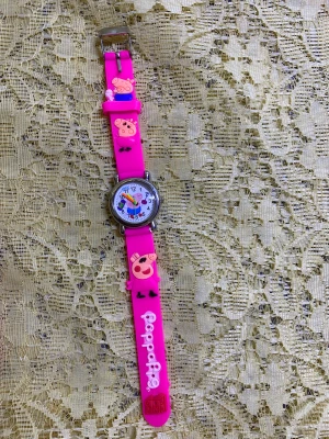 Peppa Pig rosa klocka med figurer - Säljer en färgglad Peppa Pig klocka med rosa silikonarmband och 3D-figurer av Peppa Pig. Urtavlan är vit med färgglada siffror och visare, och armbandet har Peppa Pig-text i vitt. Perfekt för dig som gillar roliga accessoarer! Nya batteri, nya klocka.  115kr/st 
